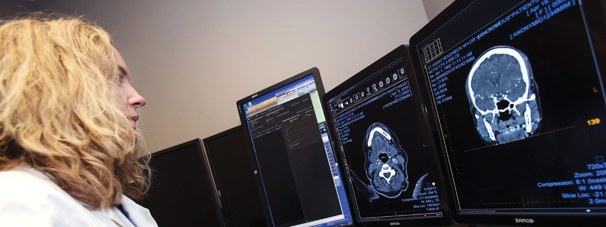 A radiologist reviewing images on a computer screen